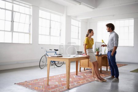 Photo for Businessman, partner and together in office for discussion, close and meeting for copywriting project. Man, woman and talk for idea, plan and gallery for research and articles at desk at work. - Royalty Free Image