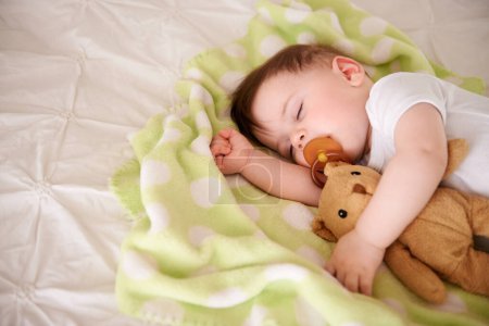 Photo for Infant, sleep and bed with teddy bear in bedroom to rest, relax with dummy and dream. Home, toddler and afternoon nap for child development, growth and innocent baby, peace and bedtime with routine. - Royalty Free Image