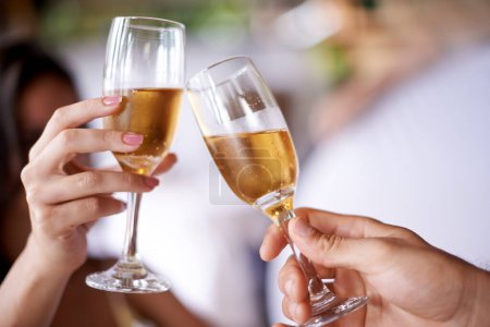 Photo for Hands, couple and glass with champagne to toast, celebrate and anniversary with date for bonding. Closeup, relationship and cheers for love with bubbles for romance on vacation, support and care - Royalty Free Image
