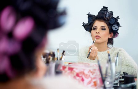 Photo for Woman, face and hair curlers or lipstick for beauty in mirror and haircare, self care or cosmetology. Model, person or hairstyle for morning routine, curling or getting ready for wellness or grooming. - Royalty Free Image