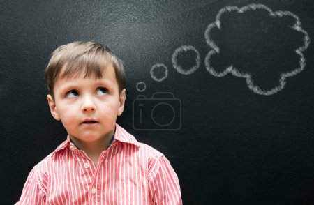 Photo for Child, boy and thinking with thought bubble on blackboard for creative idea, drawing and illustration in classroom. Student, kid and face with daydreaming, contemplating and question with chalkboard. - Royalty Free Image