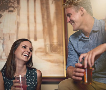 Photo for Love, smile and couple drinking in pub together for bonding, conversation and dating on weekend. Beer, happy or party with young man and woman at bar to drink alcohol from glass for celebration. - Royalty Free Image