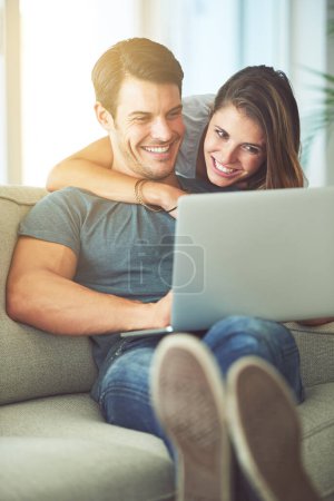 Photo for Laptop, love and woman hugging man on sofa networking on social media, website or internet. Smile, happy and female person embracing husband reading online blog with computer in living room at home - Royalty Free Image