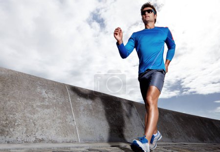 Photo for Man, road and active for running outdoors, sports and athlete for performance training in city. Male person, full body and sunglasses for workout on street, cardio and challenge or exercise by jog. - Royalty Free Image
