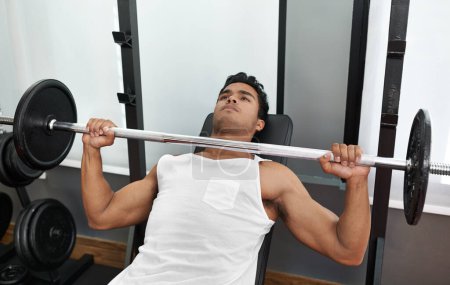 Photo for Bench, press and man at gym for exercise, workout and body building in Mexico. Healthy, person and weightlifting challenge for strong muscle, fitness or progress in training arms with barbell in club. - Royalty Free Image