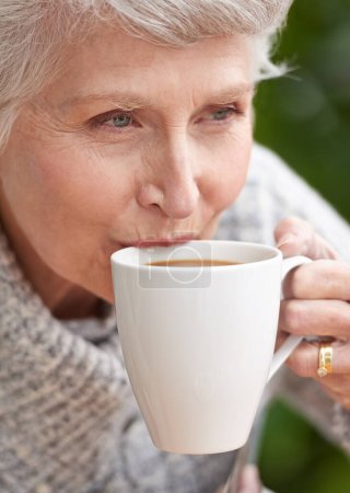 Foto de Mujer mayor, café y cara con jubilación para la vejez, y relajación. Personas mayores, abuela y primer plano con sonrisa y arrugas mientras se sienta y piensa para el ocio, beber y madurar. - Imagen libre de derechos