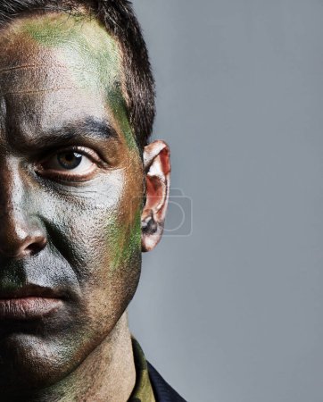 Photo for Man, portrait and soldier with face paint for camouflage, military war or battle on a gray studio background. Closeup of male person, army or commander with color dye in undercover disguise on mockup. - Royalty Free Image