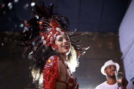 Foto de Noche, mujer o bailarina con samba en carnaval en rio de janeiro para festival brasileño con traje de plumas o sonrisa. Persona, cara o fiesta con baile, moda o música para la cultura o evento al aire libre. - Imagen libre de derechos