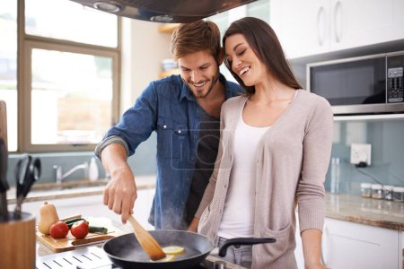 Photo for Happy couple, cooking and lunch in pan in house, love and bonding together in marriage on weekend. Man, woman or wellness by healthy food in home, care or frying on kitchen stove for romantic dinner. - Royalty Free Image