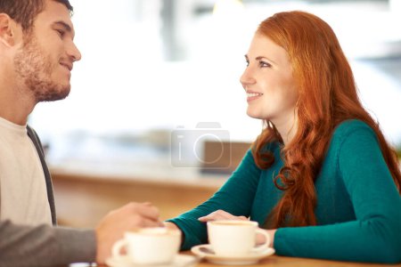 Téléchargez les photos : Couple, sourire et contact visuel pour l'amour dans le café-restaurant, soutien et bonheur pour la paix dans la relation. Adulte, femme et fille avec l'homme ou le partenaire dans le café, excité et le mariage avec le gars. - en image libre de droit