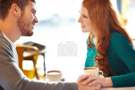 Photo for Couple, happy and smile in cafe for coffee, conversation or discussion on date with love. Support, comfortable together and trust in relationship bonding, people at table with cappuccino in mug. - Royalty Free Image