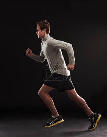 Photo for Headphones, profile or man running in studio for training, cardio exercise or workout for health wellness. Side view, fitness or sports athlete on black background to jog with radio, music or podcast. - Royalty Free Image