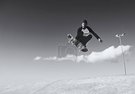 Photo for Man, skateboard and jump at skatepark for practice or hobby for trick, training and workout. Monochrome, exercise and experience on break or leisure to enjoy for activity, sport and play for fitness. - Royalty Free Image