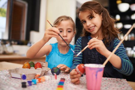 Téléchargez les photos : Fille, sœur et portrait pour peindre des œufs de Pâques avec collage, connexion et décoration festive à la maison. Enfants, pinceau et créativité avec l'art, l'amour ou ensemble pour apprendre dans la maison familiale. - en image libre de droit