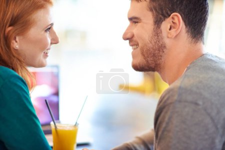 Téléchargez les photos : Couple heureux, sourire et contact visuel dans le café avec amour, romance et affection à la date anniversaire. Romantique, homme et femme dans le restaurant collant avec du jus, des boissons et des rires en relation. - en image libre de droit