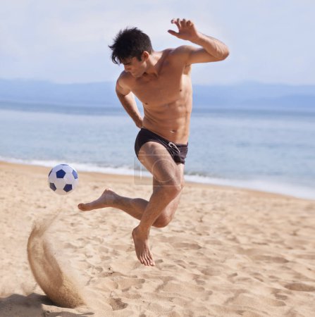 Photo for Male athlete, soccer and sand on beach, exercise and training for cardio sports. Bathing suit, football and athletic man on holiday and fun on shoreline, summer and workout and outdoor on vacation. - Royalty Free Image