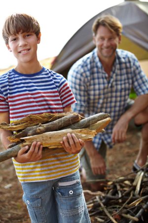 Photo for Boy, father and camping with wood in portrait for heat, cooking and learning on outdoor adventure. Child, papa and collecting firewood in forest, vacation and happy in nature by tent in Colorado. - Royalty Free Image