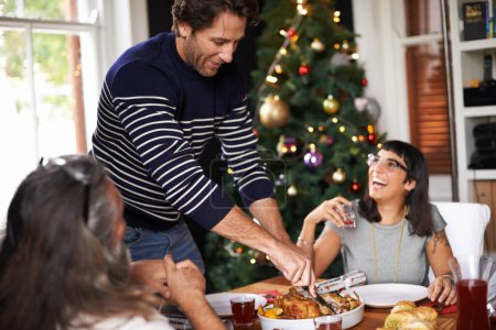 Téléchargez les photos : Famille, Noël et papa servant de la nourriture pour le déjeuner festif, coller et manger ensemble à la maison. Vacances, célébration et personnes heureuses à table avec rire, boissons et dîner de Noël tradition avec sourire. - en image libre de droit