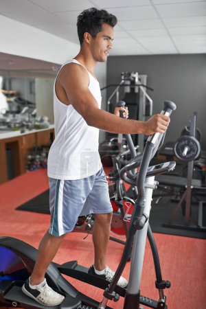 Photo for Fitness, health and man with air walker in gym for commitment to cardio improvement workout routine. Exercise, running or walking with confident young athlete on equipment for full body training. - Royalty Free Image