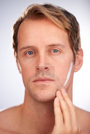 Photo for Man, portrait and skincare cream in studio for moisturiser routine for dermatology, transformation or cleaning. Male person, face and product for hygiene lotion or facial, white background or mockup. - Royalty Free Image