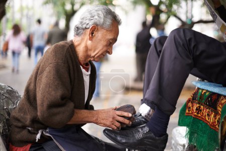 Photo for Shoe cleaner, elderly man person and shining feet, small business owner and professional on busy street. Mature, senior male and experienced worker from Puerto Rico, working with brush in city. - Royalty Free Image