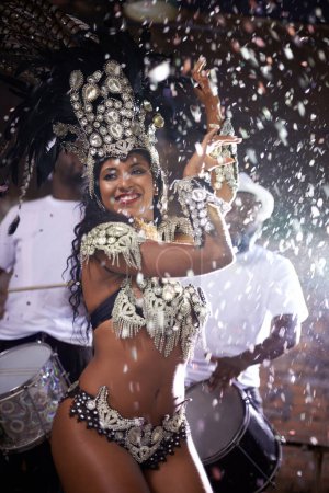 Photo for Carnival, woman and dancing in street with confetti and performance in Brazil, costume and feather head gear outdoor. Music, samba and happy for event, culture with festival entertainment and talent. - Royalty Free Image