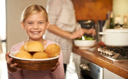 Photo for Portrait, young girl and cooking with mother, kitchen and bread basket for family dinner. Smile, proud and development of food education, preparation and nutrition or bonding with mom at home. - Royalty Free Image
