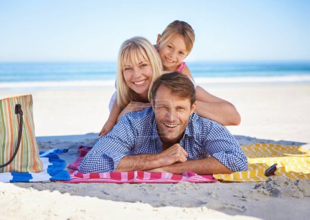 Photo for Parents, girl and portrait on blanket at beach with care, love and bonding in summer to relax on holiday. Father, mother and daughter with picnic, connection and happy by sea in sunshine on vacation. - Royalty Free Image