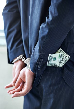 Photo for Business person, hands and cash with handcuffs for bribe, secret or corruption in financial crime. Closeup or rear view of employee with pocket money, paper or laundering finance in bribery or fraud. - Royalty Free Image