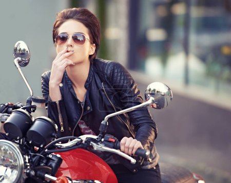 Photo for Motorcycle, leather and biker in city with cigarette for travel, or road trip as rebel. Fashion, street and woman smoker with attitude on classic or vintage bike for transportation or journey. - Royalty Free Image