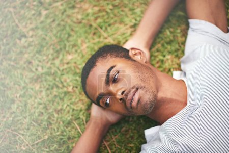 Photo for Face, relax and thinking with black man in garden of summer home for peace, wellness or mindfulness. Nature, field and grass with thoughtful young person lying on ground from above for break or rest. - Royalty Free Image