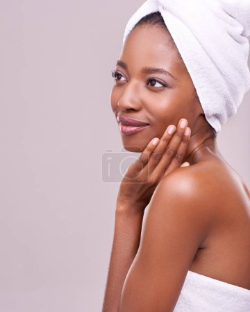 Photo for Black woman, space and hair towel in studio with skincare, wellness or beauty on purple background. Makeup, cleaning or hands on face of calm female model touching soft, skin or cosmetic glow results. - Royalty Free Image