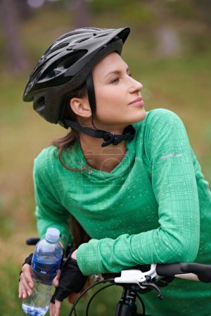 Photo for Thinking, bicycle and woman in nature to exercise with water bottle outdoor for hydration. Bicyclist, cycling and female person on bike to travel on journey, adventure or workout for sports in summer. - Royalty Free Image