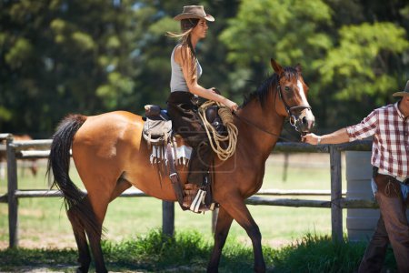 Téléchargez les photos : Femme, cheval et ferme avec cow-boy, écurie et ranch au Texas pour l'équitation de poney. Etalon, jument et enclos pour l'apprentissage équestre, campagne et cours de sport pour cavalier débutant. - en image libre de droit