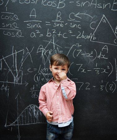 Photo for Child, boy and portrait with smile by blackboard with equations, numbers and education in classroom at school. Kid, student and happy for knowledge, learning and chalkboard with math and preschool. - Royalty Free Image
