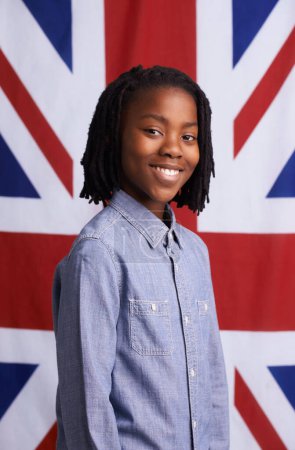 Photo for Boy, portrait and happy with UK flag or backdrop for citizenship, government and human rights. Smile and face of black child, student or kid from united kingdom and Union Jack background for support. - Royalty Free Image