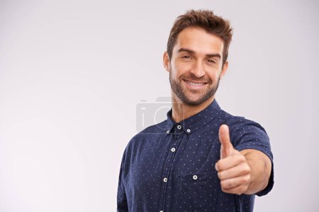 Photo for Support, portrait and man with thumbs up in studio, background and agreement in mockup space. Hand, gesture and happy for success in business with confidence and emoji for ok, thank you and yes. - Royalty Free Image