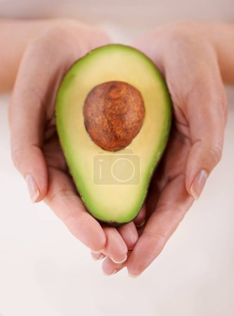 Photo for Hands, avocado and vegetable diet for health, antioxidants and minerals or vitamins for wellness. Closeup, person and holding vegan food for green detox, superfoods and omega 3 for organic skincare. - Royalty Free Image