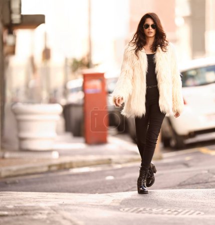 Photo for Woman, fashion and walk in confidence on sidewalk in city for winter or cold weather, street wear and downtown New York. Portrait, female person and style with trendy clothes or outfit and sunglasses. - Royalty Free Image