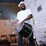 Music, carnival and drummer or performance, show and musician on stage. Concert, entertainment or fun celebration for musical artist, smile and drum for male Brazilian talent from low angle.