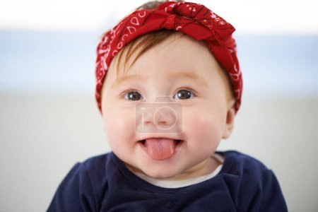 Photo for Portrait, tongue and cheerful baby fashion in family home, cute and trendy street style on curious girl toddler. Creative, child development and growth, adorable headband accessory on happy smile kid. - Royalty Free Image