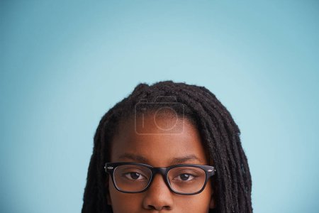Téléchargez les photos : Vision, lunettes ou gamin noir en studio pour soins oculaires, bien-être ou optométrie sur fond bleu. Cadre, maquette ou gros plan du modèle masculin adolescent africain avec test de vue, de prescription ou d'ophtalmologie. - en image libre de droit