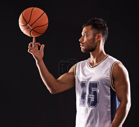 Photo for Man, basketball playing and finger or sports game in studio or professional exercise, athlete or black background. Male person, training and fitness spinning or workout competition, uniform or mockup. - Royalty Free Image