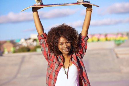 Téléchargez les photos : Portrait, sourire et femme avec skateboard pour la célébration, le succès ou la victoire avec les bras levés en plein air de la ville. Victoire, skate park et personne heureuse en vêtements décontractés avec succès en Afrique du Sud. - en image libre de droit