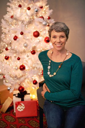 Photo for Christmas, tree and portrait of mature woman in home for holiday with presents on vacation. Happy, person and relax on with festive xmas decoration and gift box in living room and enjoy retirement. - Royalty Free Image