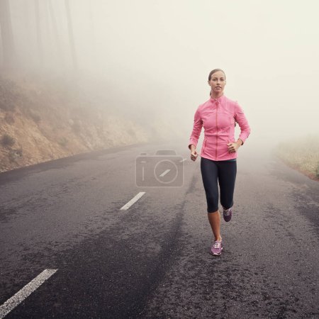 Photo for Nature, fitness and woman athlete running on mountain road for race, marathon or competition training. Sports, exercise and female person with cardio workout in misty outdoor woods or forest - Royalty Free Image