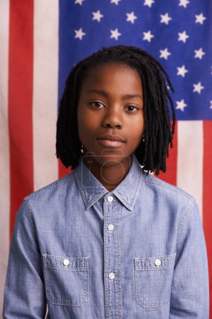 Téléchargez les photos : Enfants, portrait et garçon noir avec drapeau américain en studio pour la liberté, l'événement ou la fierté patriotique. Visage, immigration et enfant africain avec bannière américaine pour le Jour du Souvenir, l'histoire ou la bannière des droits de l'homme. - en image libre de droit