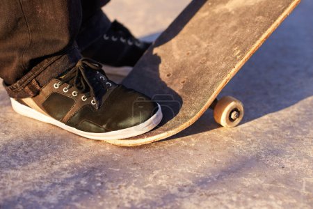 Photo for Closeup, skateboard and person with sneakers, skill and training with technique or fitness. Skater, practice or athlete with energy, sunshine or performance with weekend break, shoes or skating style. - Royalty Free Image
