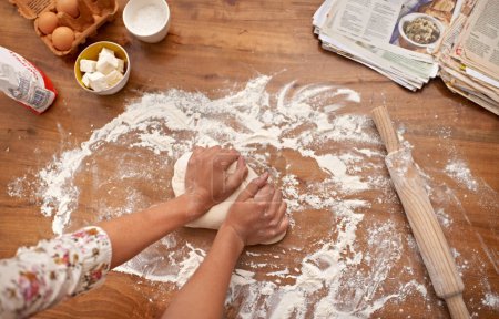 Photo for Chef, hands and recipe for dough on table, baking in kitchen and above process in bakery. Person, prepare and press bread with flour for meal prep and learning information from guide in book. - Royalty Free Image