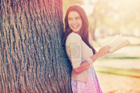 Photo for Tree trunk, portrait and woman with smile for novel, book and fiction in nature to relax in park. Adult, girl and female person with confidence for knowledge, happy and joy for reading in summer. - Royalty Free Image